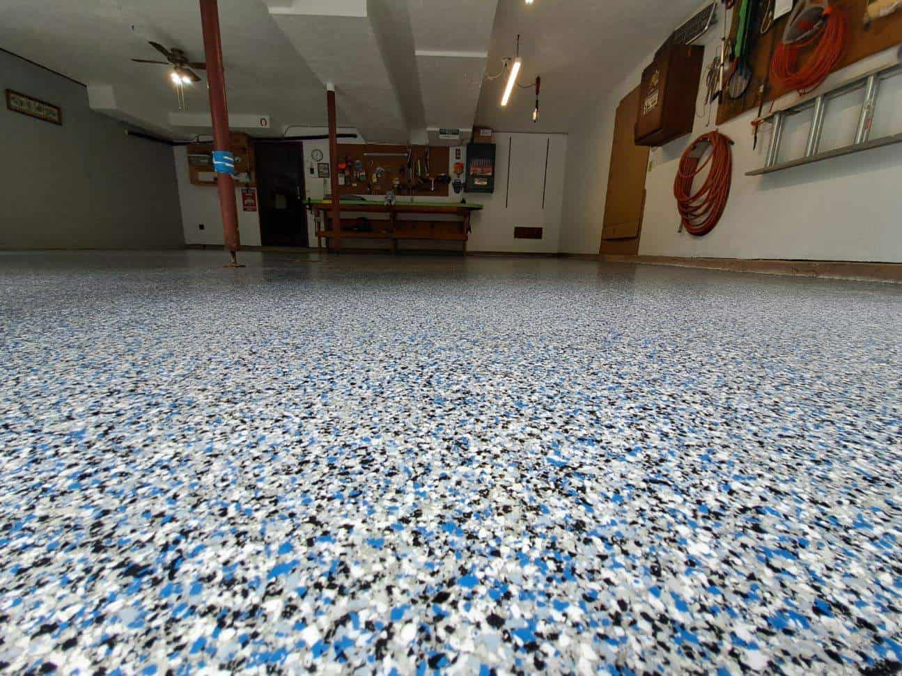 This image shows a durable epoxy-coated garage floor by J&P Coatings, offering a clean and organized workspace.