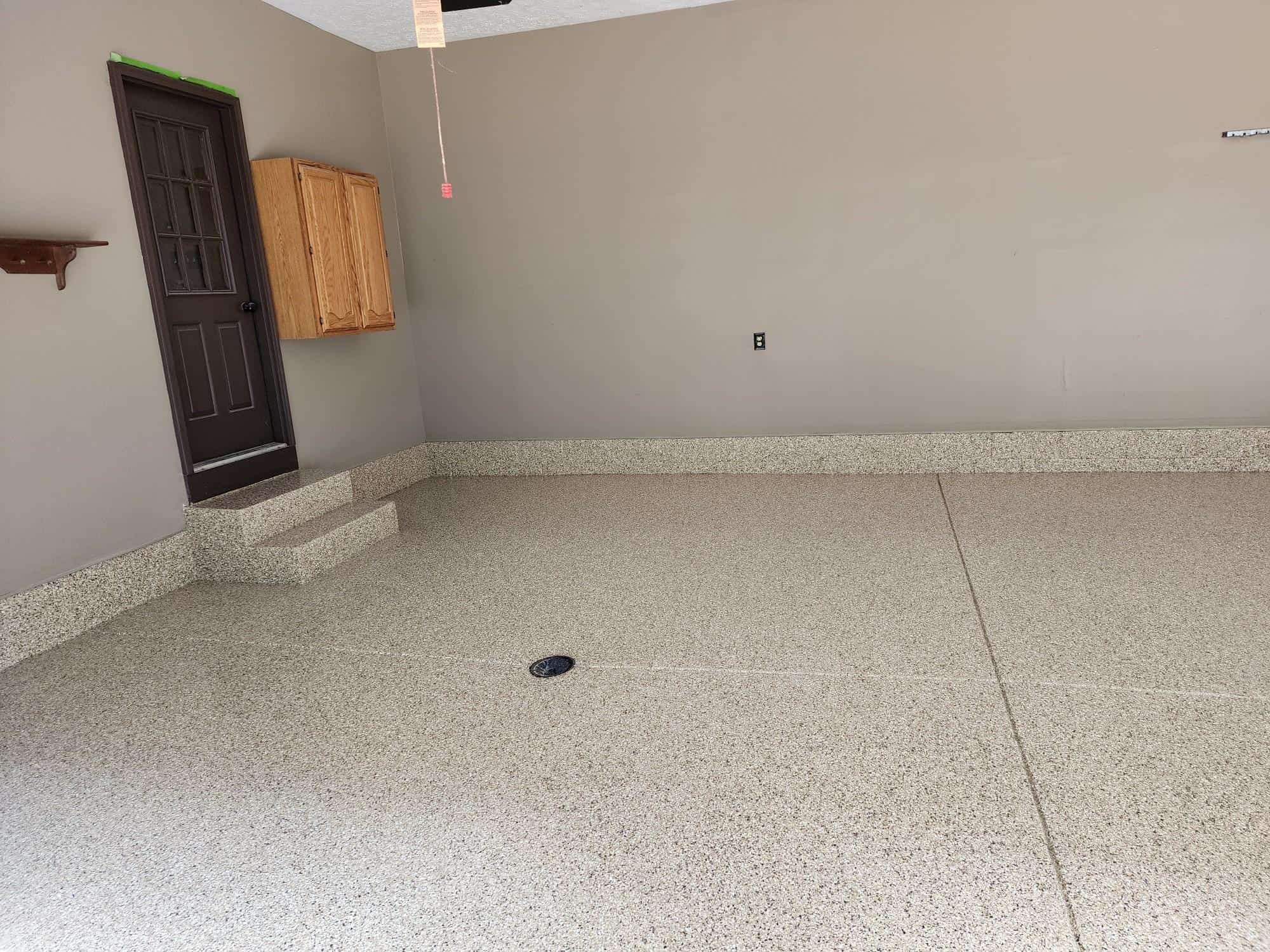 A freshly finished garage shows J&P Coatings&rsquo; smooth epoxy flooring. The space looks neat and ready to use.