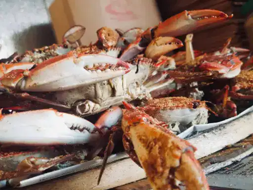 A group of cooked crabs is served on a tray, resting on a table finished by J&P Coatings.