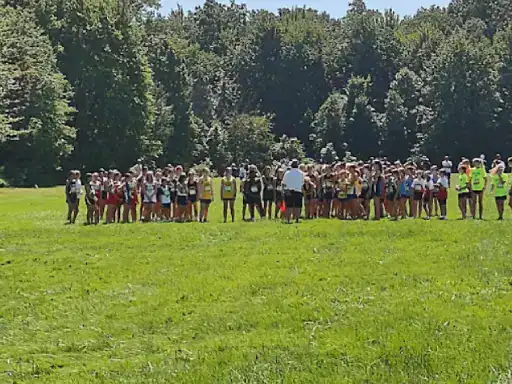 A group of runners gets ready to start a race outside, showing teamwork and excitement. J&P Coatings staff help organize the event.
