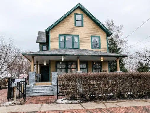 A cozy two-story house shows off its neat yard and a porch where people can relax. The walkway and patio have smooth, clean coatings by J&P Coatings, making the home look inviting and well cared for. alt text: Home with fresh concrete patio coating by J&P Coatings.