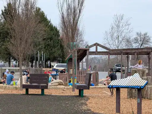 People of all ages are having fun and relaxing in a park. The comfortable concrete coatings by J&P Coatings help make the playground safe and enjoyable for everyone.