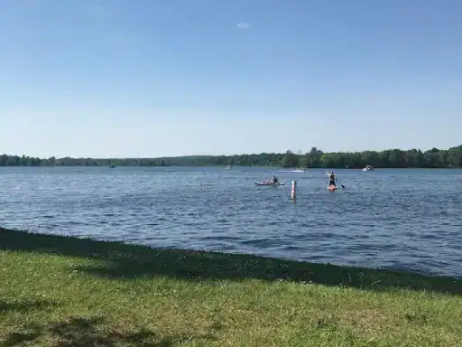 A peaceful lake where two people enjoy kayaking, showing how relaxing time can be after finishing a concrete patio with J&P Coatings.