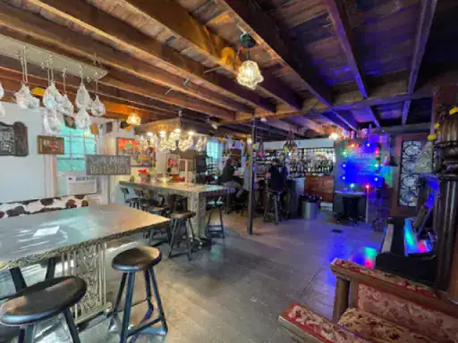 The image shows a friendly bar with welcoming decor and a polished floor, similar to those finished by J&P Coatings. The scene suggests a comfortable place where people feel at ease and enjoy their time together. Alt Text: A welcoming bar with floors reflecting the quality work of J&P Coatings.