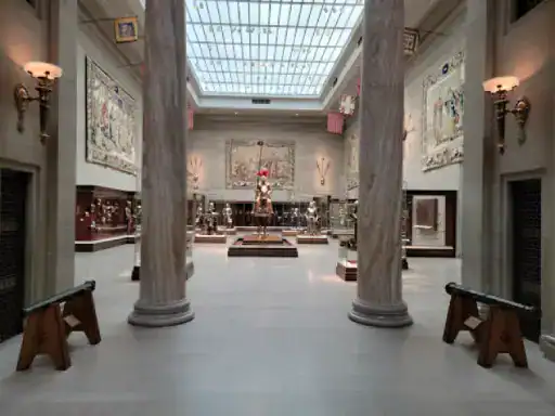 This image shows a large museum hall that looks elegant and impressive. The floors shine brightly, showing the high quality and careful work by J&P Coatings. In the center, there is a medieval knight in armor, which adds to the museum’s historic feeling. Alt-text: A bright, polished floor in a grand museum highlights expert work by J&P Coatings.