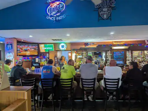 J&P Coatings shows a group of friends enjoying drinks at a busy bar as the bartender serves customers in a bright, fun setting.