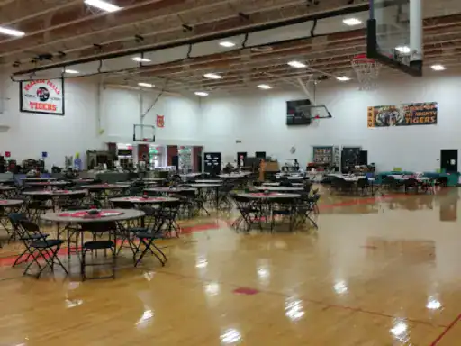 A gym is ready for an event, showing J&P Coatings’ floor work. The space feels welcoming with tables set up for guests.
