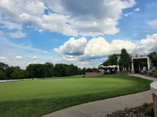 People relax on the clubhouse patio after golfing, enjoying the smooth and attractive concrete coatings by J&P Coatings.