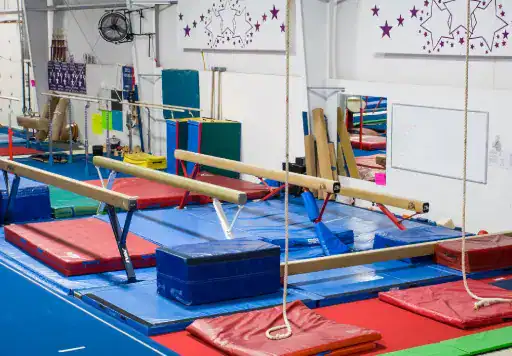 A gymnastics gym is shown with safe floors installed by J&P Coatings. The space looks fun and ready for active practice.