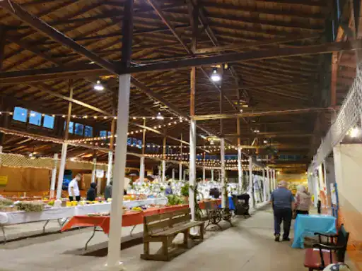 A lively indoor market scene shows people enjoying a welcoming space, just like patios finished with J&P Coatings.