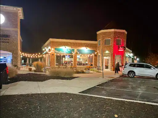 A calm evening outside a restaurant shows a J&P Coatings work vehicle parked nearby, highlighting their local presence.