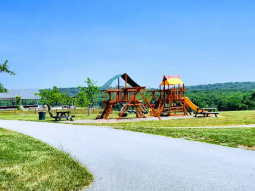 A well-kept park features a fun playground and picnic area. A smooth, coated path by J&P Coatings leads through the park.