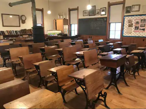 A classroom with classic wooden floors and an old-time style that brings a sense of nostalgia, coated by J&P Coatings. Alt Text: Classic classroom with wooden floors and vintage look by J&P Coatings.