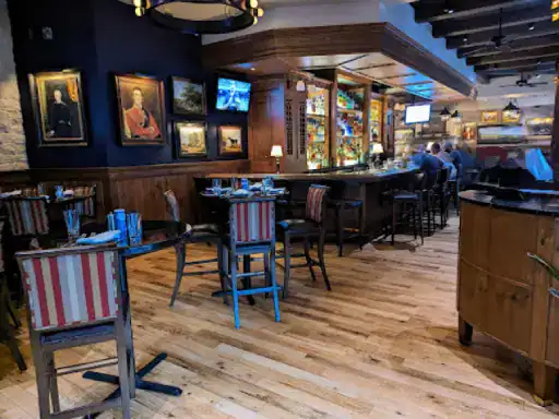 A restaurant with inviting wooden floors by J&P Coatings shows an active, welcoming space where people gather to enjoy a meal.