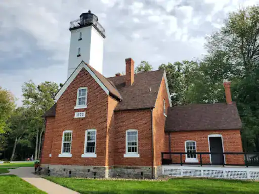 A well-maintained lighthouse stands on a green lawn, showing how J&P Coatings protects and preserves important buildings.