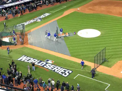 A group gathers by the WORLD SERIES logo at a baseball field, showing how J&P Coatings helps make spaces stand out.