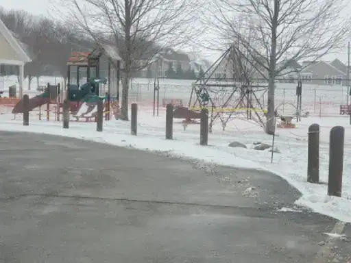 A playground in winter shows safe, snow-dusted surfaces. This highlights J&P Coatings’ work for outdoor areas.