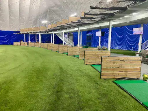 J&P Coatings helped make this indoor golf range comfortable and safe for players. The space has strong floors perfect for golfing. Each player has their own area to practice, and safety nets help protect everyone. Blue curtains line the walls, creating a calm setting for golf practice. Alt text: Indoor golf range made safer and more comfortable by J&P Coatings’ flooring.