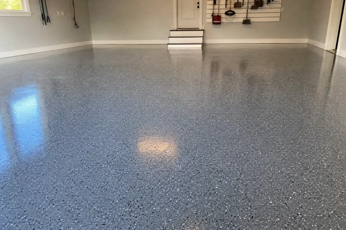 The image shows a neat, durable J&P Coatings gray garage floor that looks freshly finished and well-organized.